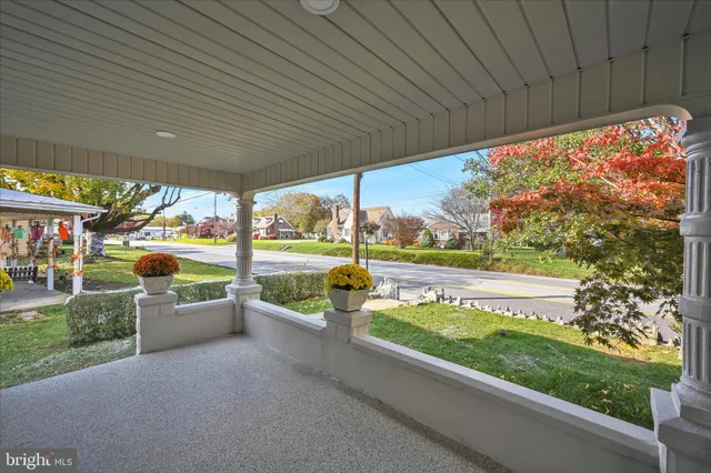 a view of a patio with a table chairs potted plants and palm trees