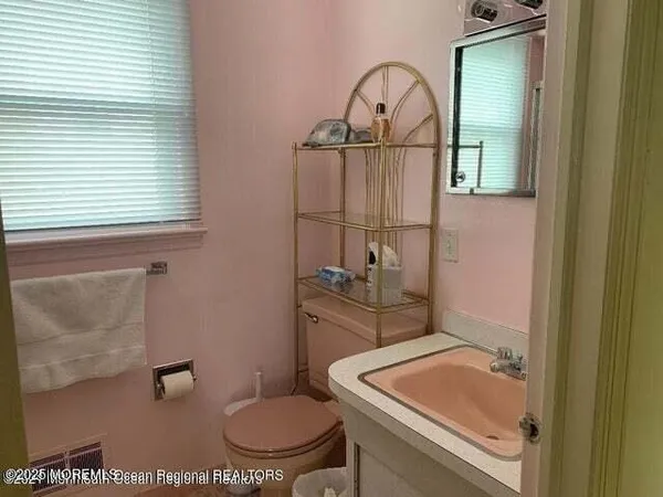 a bathroom with a toilet a sink and a window