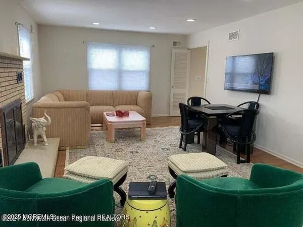 a living room with furniture and a wooden floor