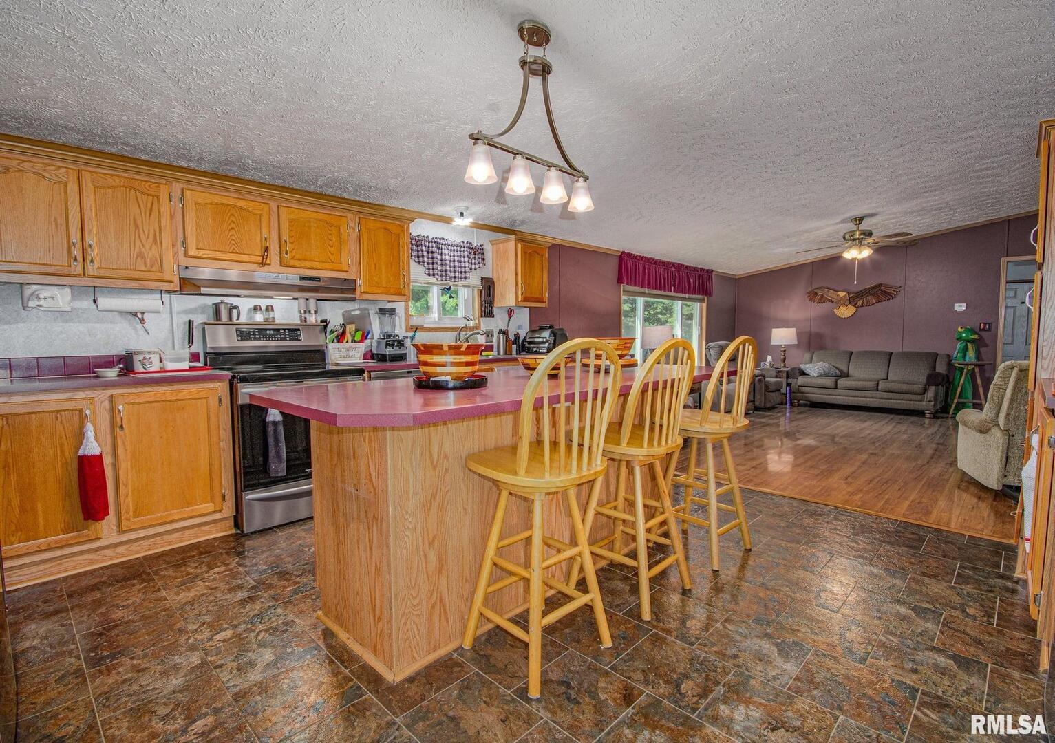 16807 East Kendall Road Mount Vernon, IL 62864 - Photo 6 of 28 a dining room with stainless steel appliances granite countertop a kitchen island a stove a sink a dining table and chairs with wooden floor