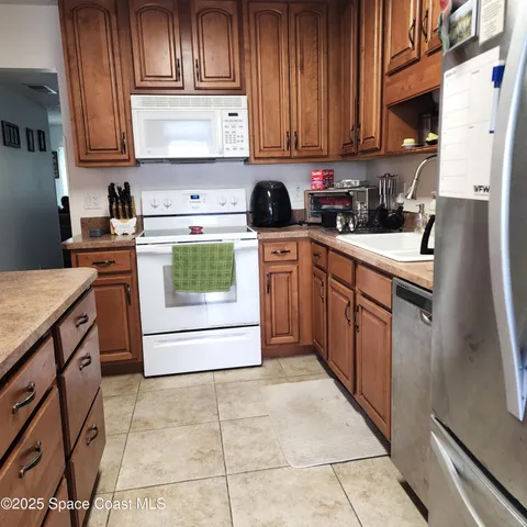 a kitchen with stainless steel appliances granite countertop a stove top oven a sink a counter space and cabinets