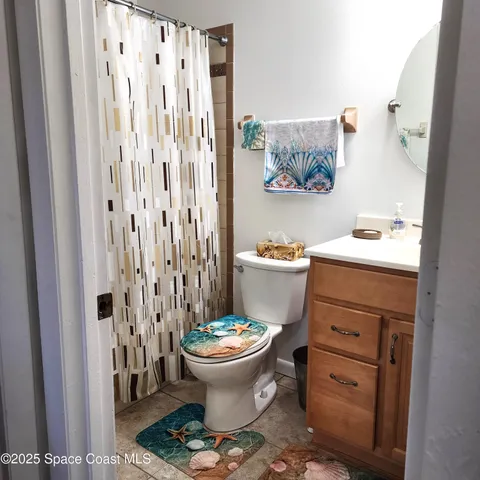 a bathroom with a sink toilet and shower curtain