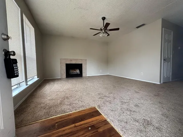 a view of a livingroom with a fireplace and a ceiling fan