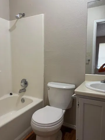 a white toilet sitting next to a bath tub
