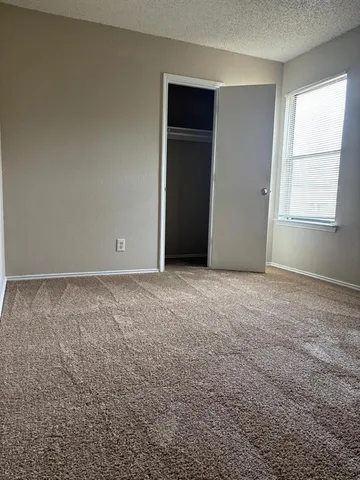 an empty room with windows and closet