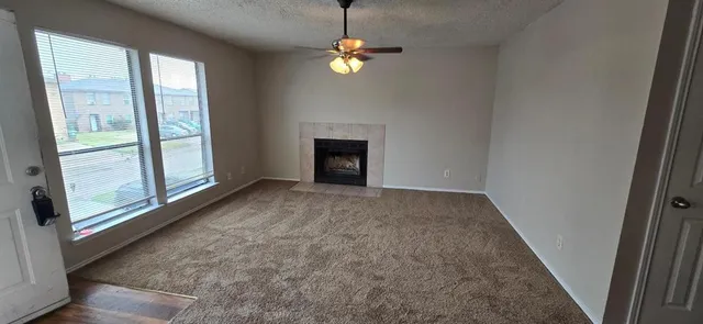 a view of an empty room with a fireplace and a window