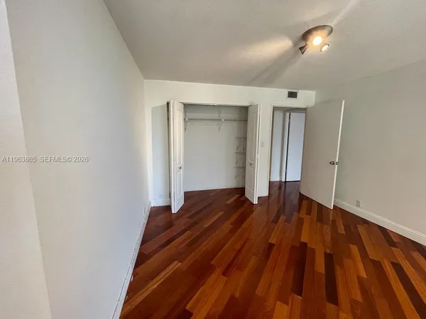 a view of empty room with wooden floor