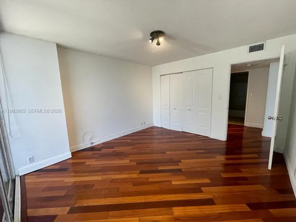 a view of empty room with wooden floor