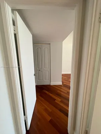 a view of a hallway with wooden floor and stairs