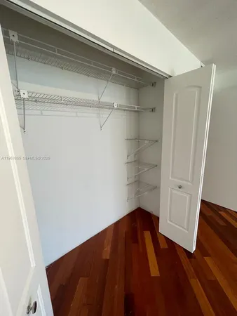 a view of a room with wooden floor and white walls