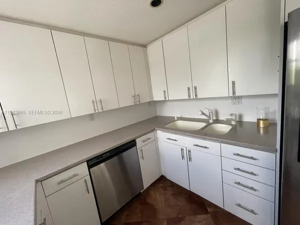 a kitchen with granite countertop white cabinets and sink