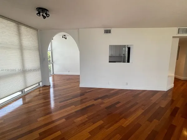 a view of empty room with wooden floor