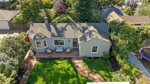 aerial view of house with a yard and trees