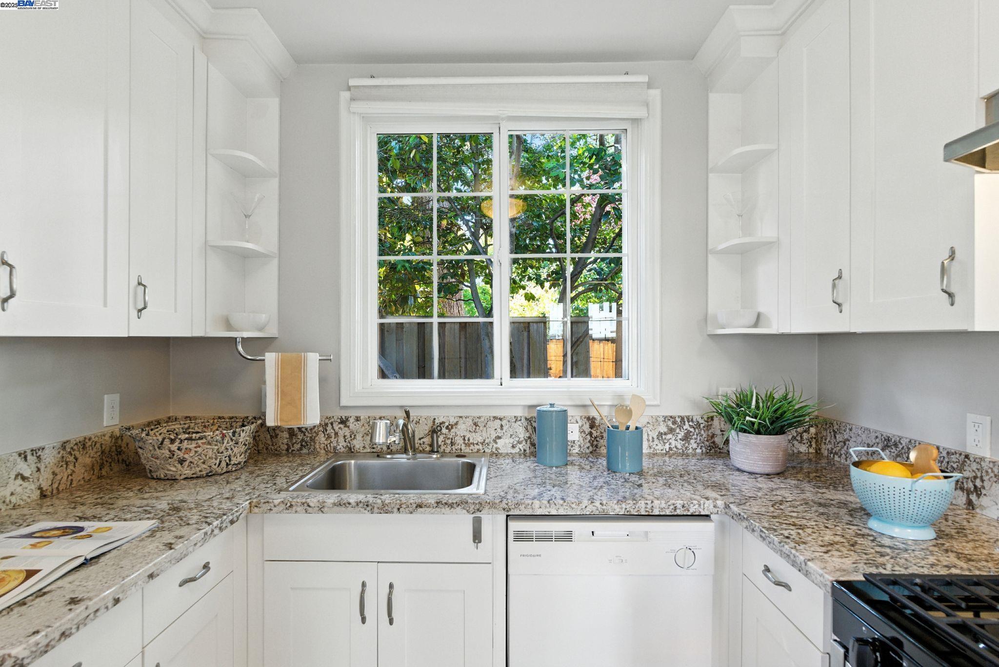 1247 Sherman Street Alameda, CA 94501 - Photo 23 of 50 a kitchen with granite countertop stainless steel appliances a sink a window and white cabinets