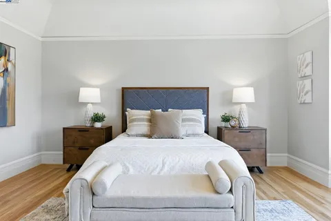 a bedroom with a large bed chandelier and a window