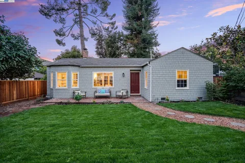 a view of a house with a yard and sitting area