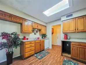 a kitchen with granite countertop a sink cabinets stainless steel appliances and a potted plant