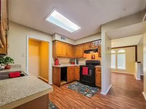 a view of a kitchen with fridge and wooden floor