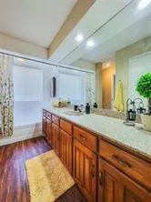 a spacious bathroom with stainless steel appliances double vanity sink and a mirror