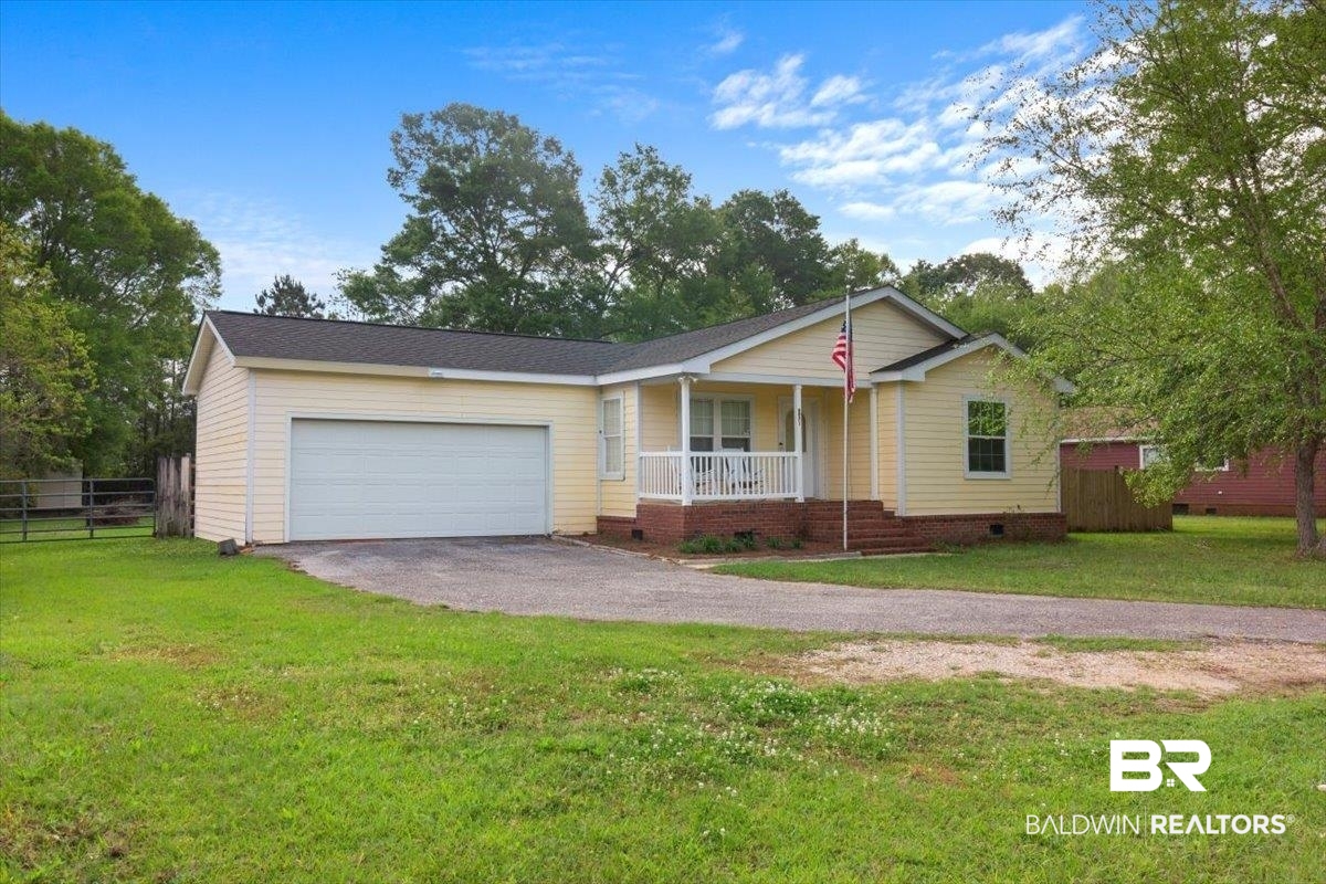 6971 March Road Theodore, AL 36582 - Photo 2 of 26 Ranch-style home with fence, an attached garage, aphalt driveway, a front lawn, and a porch