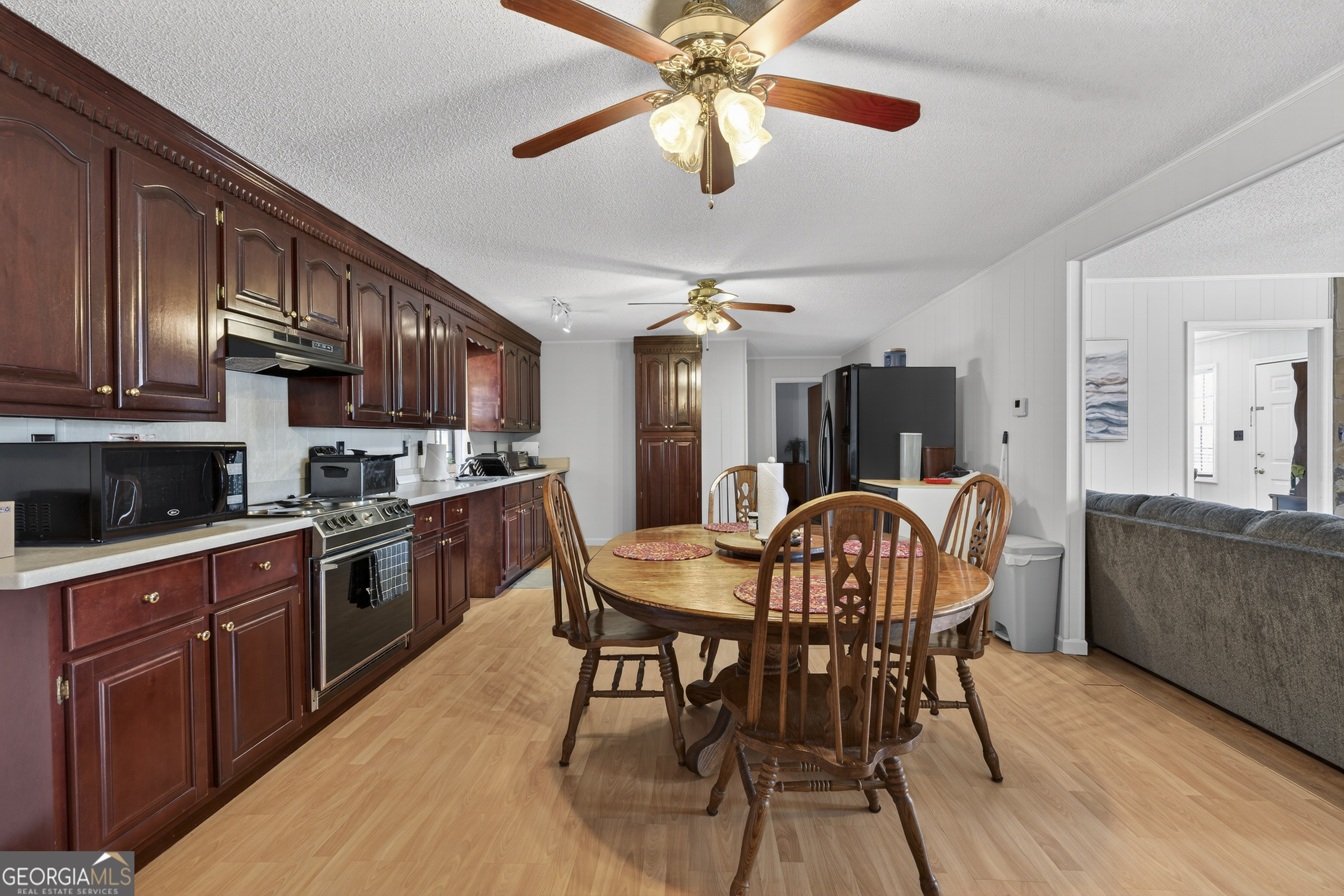 231 B Little Road Northwest Milledgeville, GA 31061 - Photo 13 of 67 a kitchen with stainless steel appliances granite countertop a dining table chairs refrigerator and cabinets