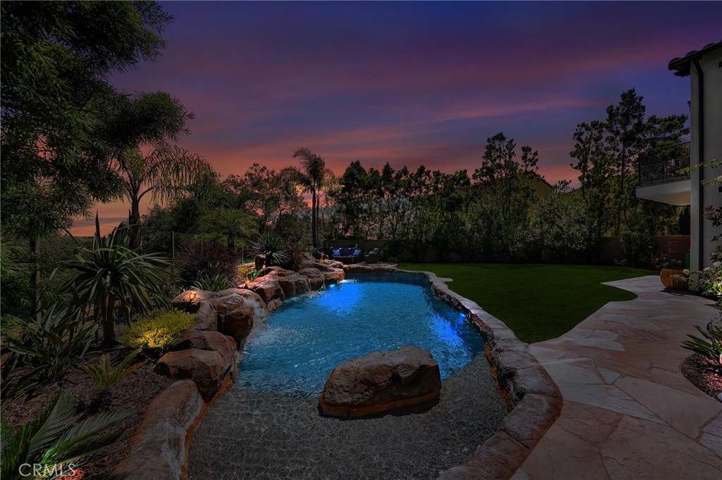 11 Hidden Pass Newport Coast, CA 92657 - Photo 5 of 59 a view of a swimming pool with lawn chairs under an umbrella