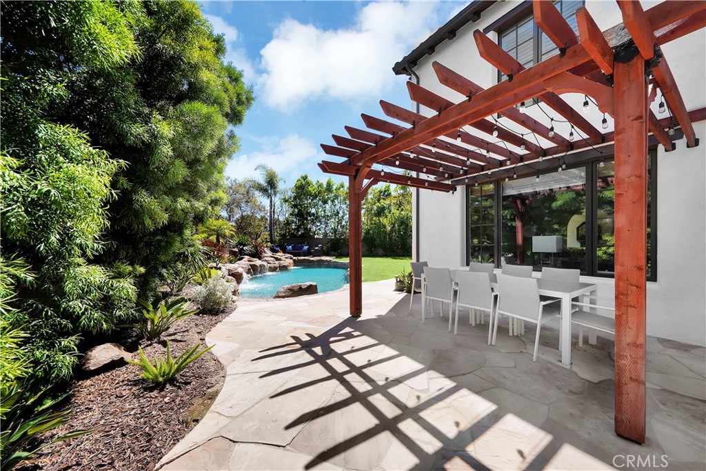 11 Hidden Pass Newport Coast, CA 92657 - Photo 52 of 59 a view of a patio with a dining table and chairs with wooden floor and fence