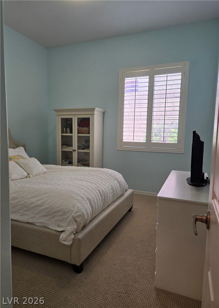 2567 Dirleton Place Henderson, NV 89044 - Photo 42 of 67 Guest Bedroom. Sun-filled bedroom featuring a large window with privacy shutters and plush carpeting throughout.