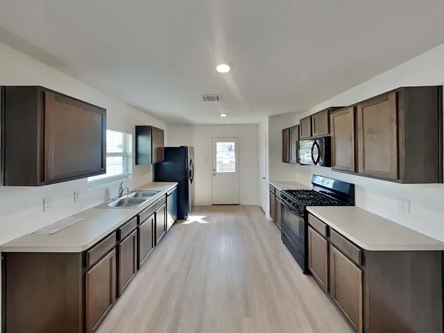 a kitchen with stainless steel appliances a sink stove and refrigerator