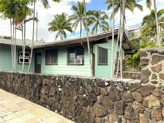 a front view of a house with a garden