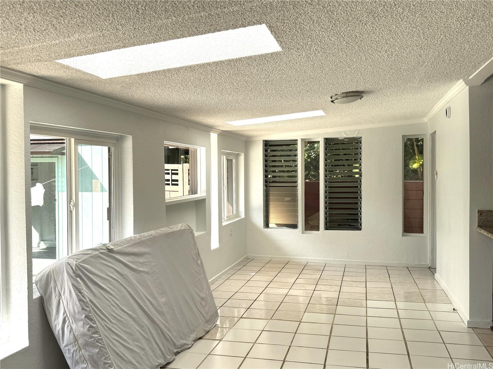 678 Auwina Street, Unit 3 Kailua, HI 96734 - Photo 6 of 11 a view of a bedroom with wooden floor and windows