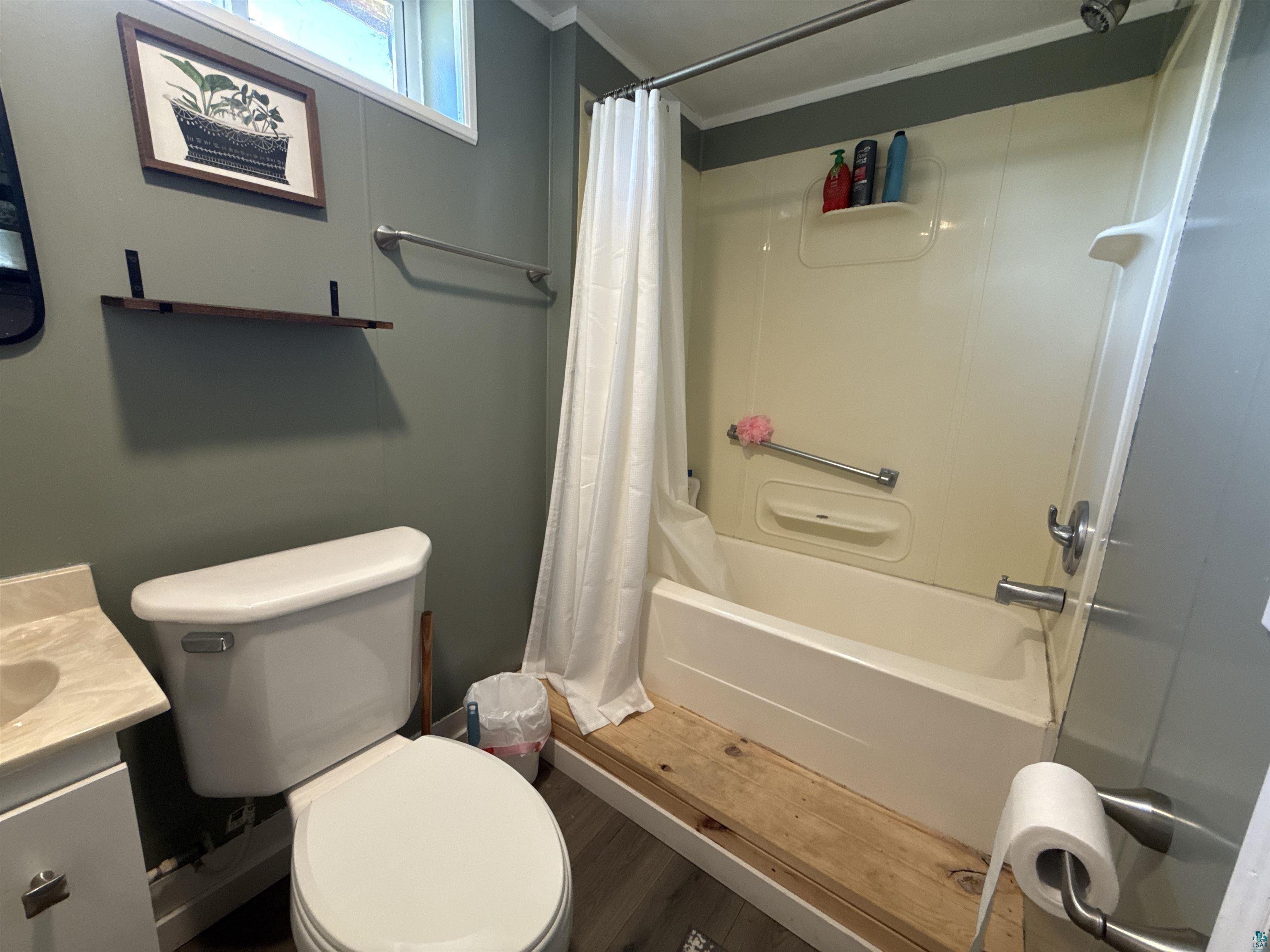 402 Alcohol Road Wrenshall, MN 55797 - Photo 23 of 24 Bathtub with integrated shower, wall-mounted grab bar, and white shower curtain