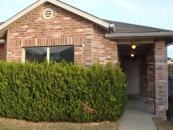 a front view of a house with plants