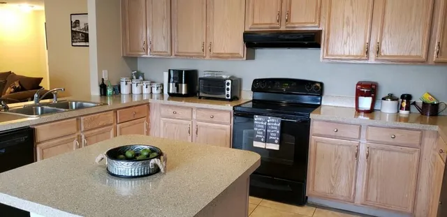 a kitchen with stainless steel appliances granite countertop a sink a stove and white cabinets