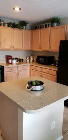 a kitchen with stainless steel appliances granite countertop a refrigerator a stove and a sink