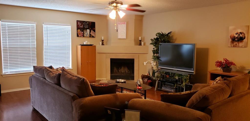 4173 Tupelo Trail Fort Worth, TX 76244 - Photo 4 of 10 a living room with furniture a fireplace and a flat screen tv