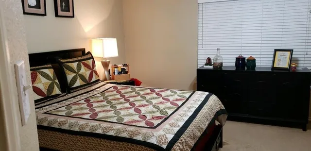 a bed sitting in a bedroom next to a window