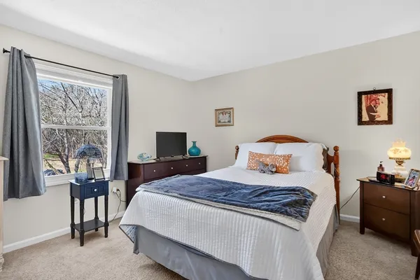 a bedroom with a bed and a flat tv screen on dresser