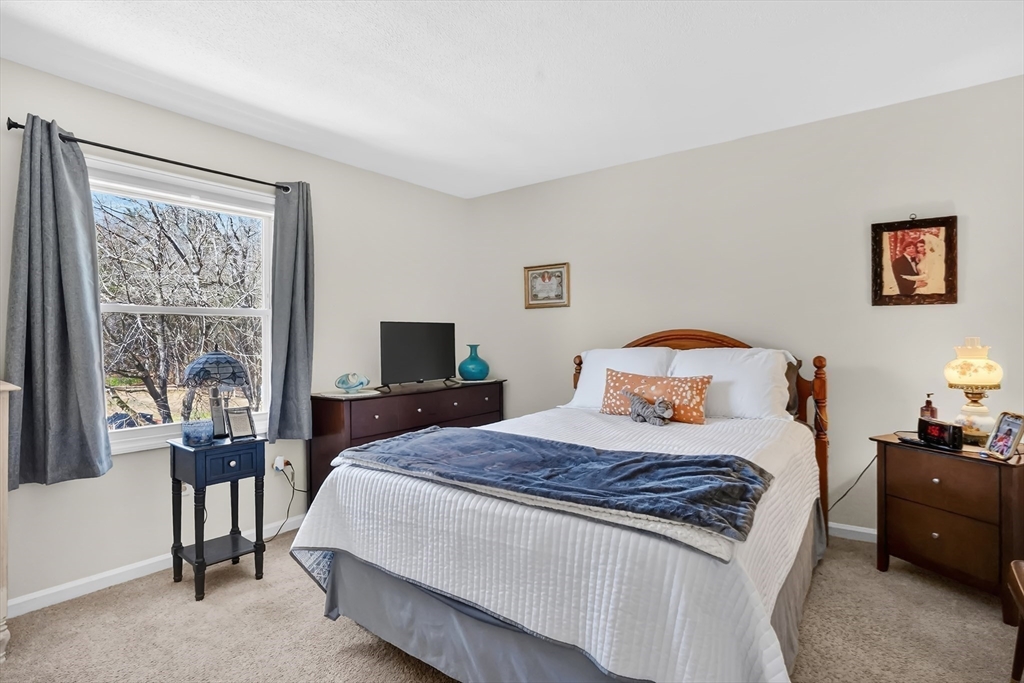 80 Yorktown Drive, Unit 80 Springfield, MA 01108 - Photo 14 of 24 a bedroom with a bed and a flat tv screen on dresser