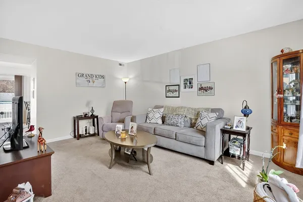 a living room with furniture a flat screen tv and a wall painting