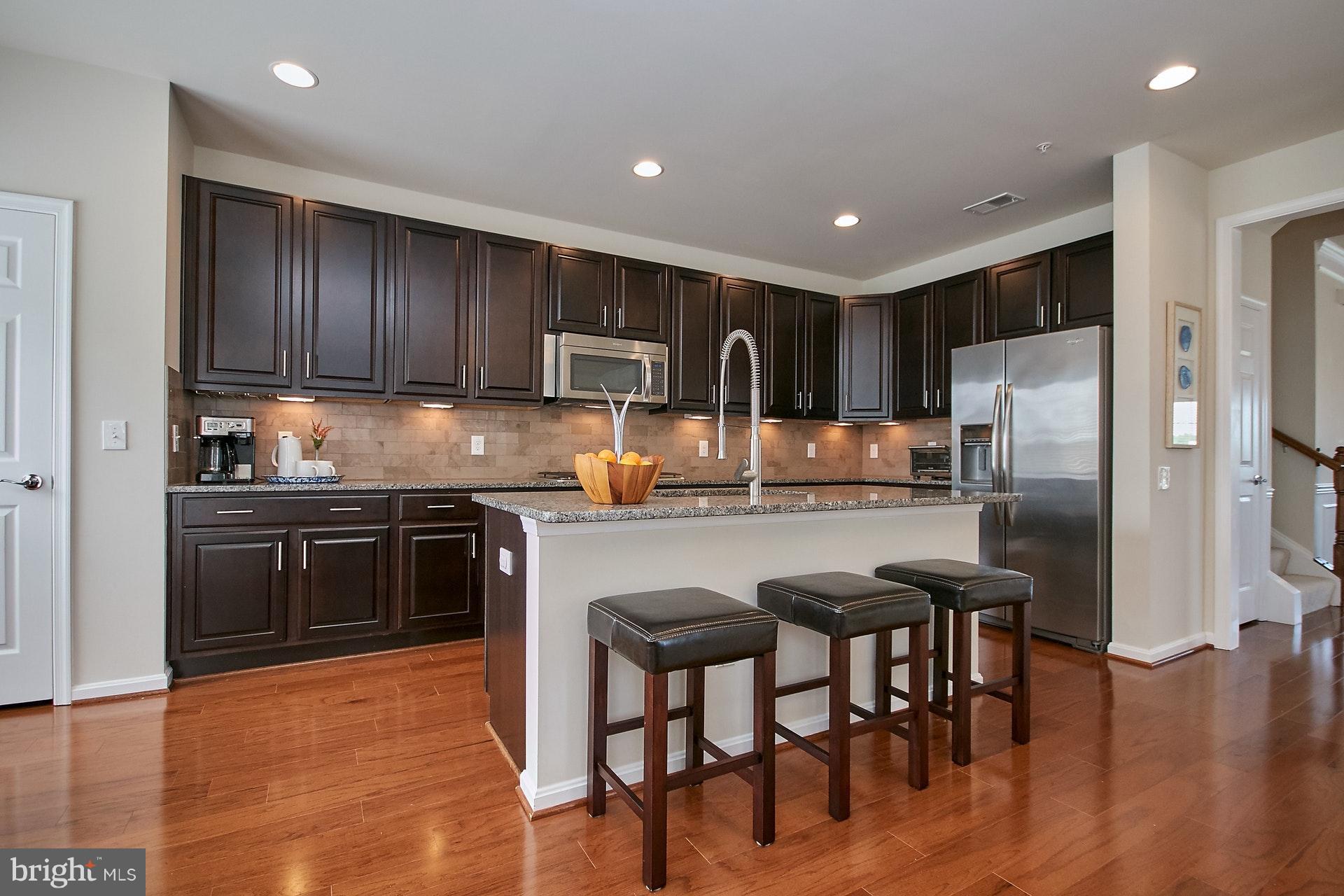 3073 Rittenhouse Circle, Unit 60 Fairfax, VA 22031 - Photo 10 of 30 a kitchen with kitchen island granite countertop wooden cabinets and stainless steel appliances