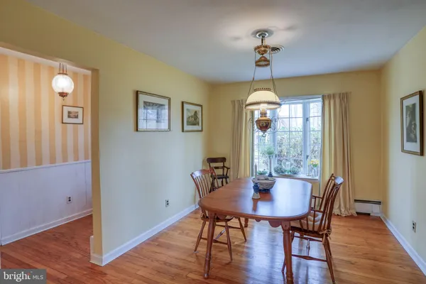 a kitchen with stainless steel appliances granite countertop a sink a stove a dining table and chairs