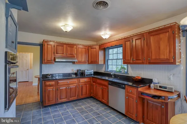 a living room with furniture a large window and wooden floor