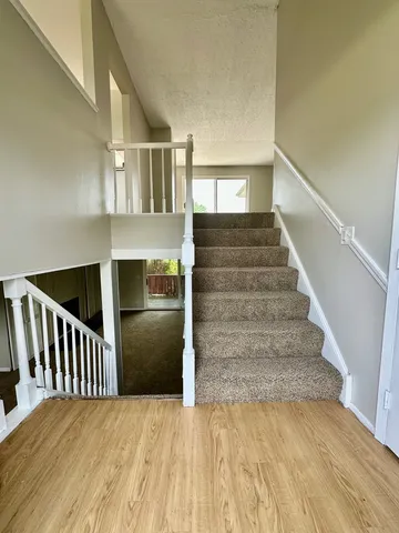 a view of entryway and hall with wooden floor
