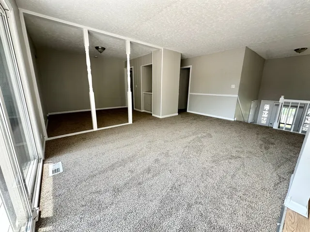an empty room with closet and mirror