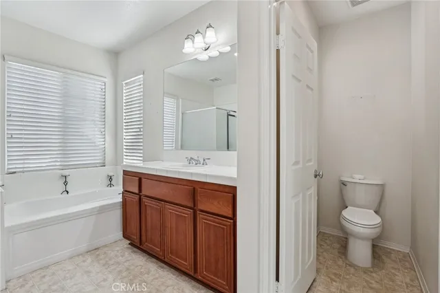 a spacious bathroom with a tub sink and mirror