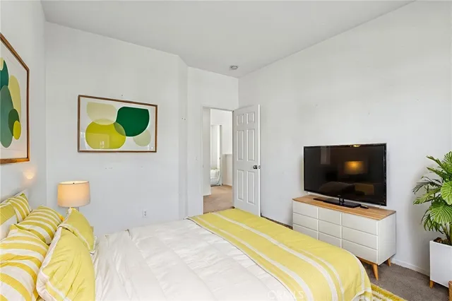 a bedroom with a bed and painting on the wall