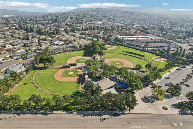 an aerial view of residential houses with outdoor space and trees