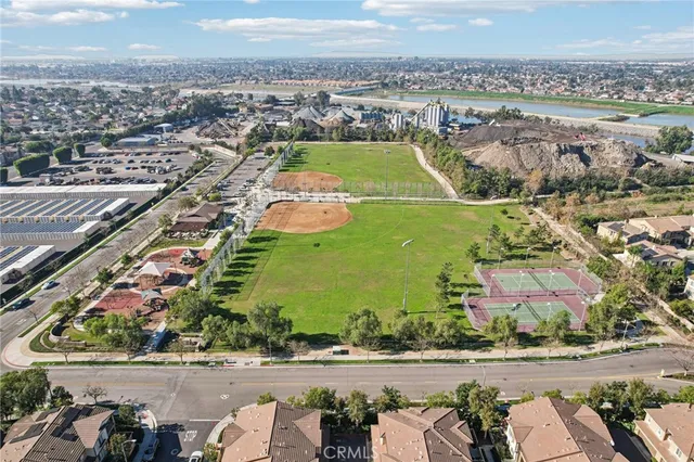 an aerial view of a residential houses with outdoor space and a lake view in back