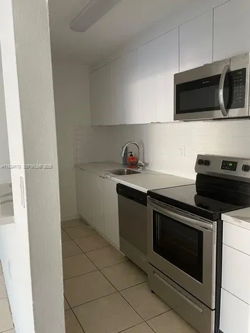 a kitchen with stainless steel appliances a stove microwave and sink
